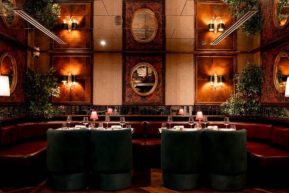 The dining room at Bulbul, oval mirrors and a curved banquette